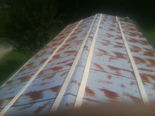 Rusted metal roof panels with new wood purlins before replacement — Storm Damage Roof Repair in Bon Air by Roofing Brothers