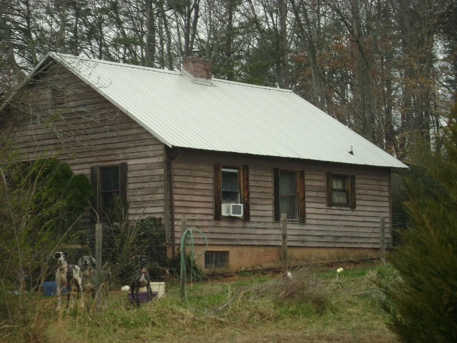 White metal roof on an old wood sided farmhouse, from a Metal Roof Installation job in Bon Air